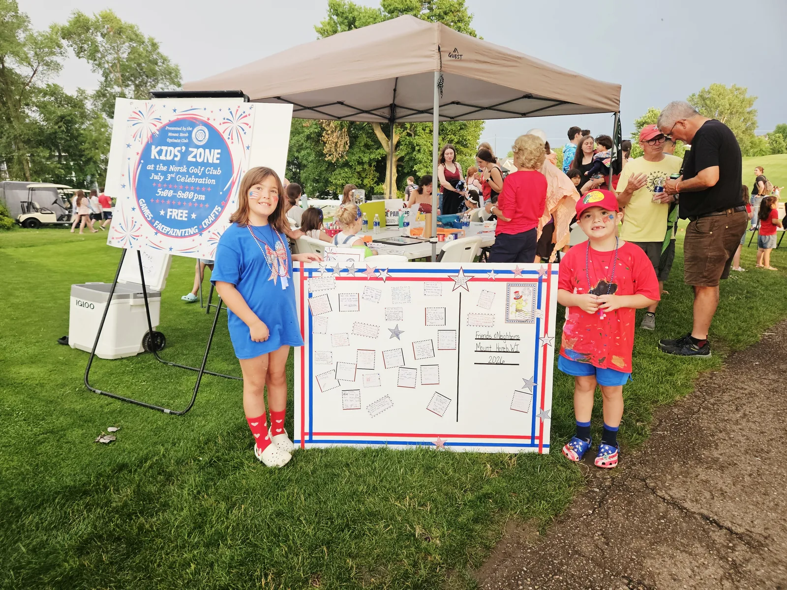Two children beside the Friends and Neighbors thank-you board, where kids wrote notes to people in Mount Horeb